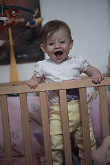 Image showing cute little one year old baby and making first steps in bed