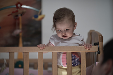 Image showing cute little one year old baby and making first steps in bed