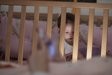 Image showing cute little one year old baby and making first steps in bed