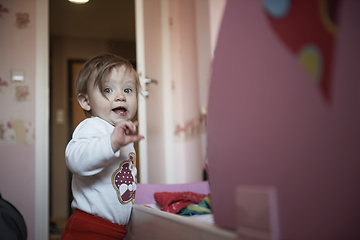 Image showing cute little one year old baby and making first steps