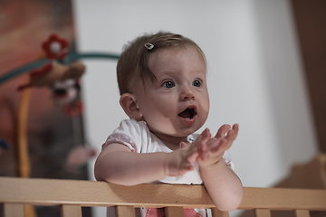 Image showing cute little one year old baby and making first steps in bed