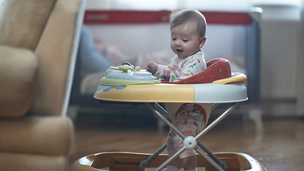 Image showing baby learning to walk in walker