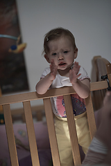 Image showing cute little one year old baby and making first steps in bed