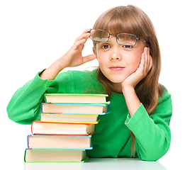 Image showing Little girl is reading a book