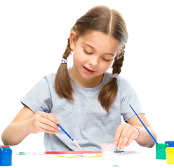 Image showing Little girl is painting with gouache