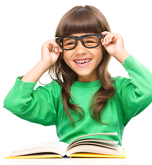 Image showing Little girl is reading a book