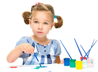 Image showing Little girl is painting with gouache