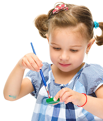 Image showing Little girl is painting with gouache