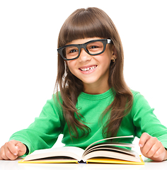 Image showing Little girl is reading a book