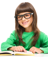 Image showing Little girl is reading a book