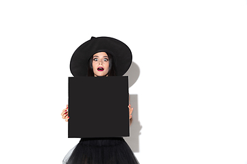 Image showing Young woman in hat and dress as a witch on white background