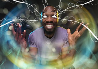 Image showing Enthusiastic gamer. Joyful young man holding a video game controller