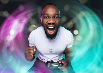 Image showing Enthusiastic gamer. Joyful young man holding a video game controller