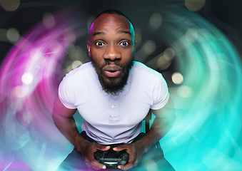 Image showing Enthusiastic gamer. Joyful young man holding a video game controller