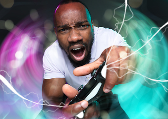 Image showing Enthusiastic gamer. Joyful young man holding a video game controller