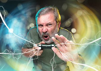 Image showing Enthusiastic gamer. Joyful man holding a video game controller