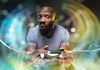 Image showing Enthusiastic gamer. Joyful young man holding a video game controller