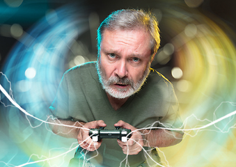 Image showing Enthusiastic gamer. Joyful man holding a video game controller