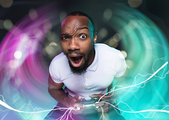 Image showing Enthusiastic gamer. Joyful young man holding a video game controller