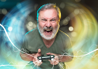 Image showing Enthusiastic gamer. Joyful man holding a video game controller