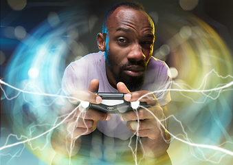 Image showing Enthusiastic gamer. Joyful young man holding a video game controller