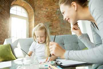 Image showing Teacher and little girl, or mom and daughter. Homeschooling concept