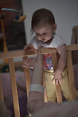 Image showing cute little one year old baby and making first steps in bed