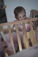 Image showing cute little one year old baby and making first steps in bed