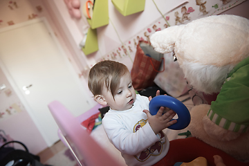 Image showing cute little one year old baby and making first steps