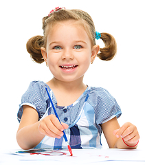 Image showing Little girl is painting with gouache