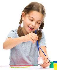 Image showing Little girl is painting with gouache