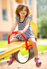 Image showing Young happy girl is swinging in playground