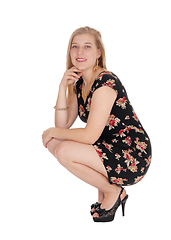 Image showing Beautiful young woman in a dress crouching