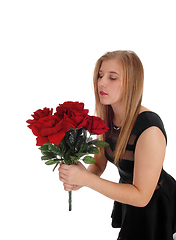 Image showing Beautiful woman with a big bunch red roses