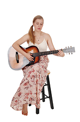 Image showing Woman sitting with her guitar and singing