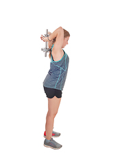 Image showing Young woman lifting dumbbell's over her head