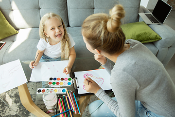 Image showing Teacher and little girl, or mom and daughter. Homeschooling concept