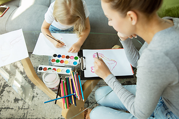 Image showing Teacher and little girl, or mom and daughter. Homeschooling concept