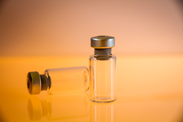 Image showing two vaccine bottles on orange background