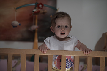 Image showing cute little one year old baby and making first steps in bed