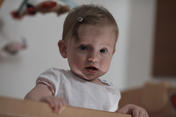 Image showing cute little one year old baby and making first steps in bed