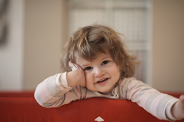 Image showing little baby girl with strange hairstyle and curlers