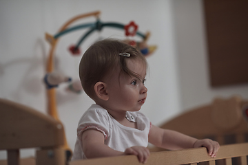 Image showing cute little one year old baby and making first steps in bed