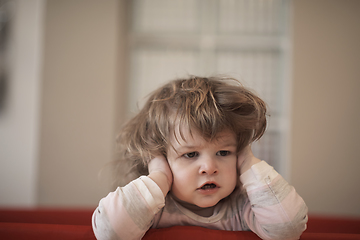 Image showing little baby girl with strange hairstyle and curlers