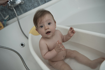 Image showing cute little baby girl taking a bath