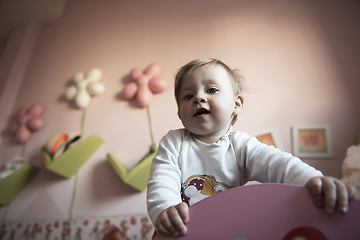 Image showing cute little one year old baby and making first steps