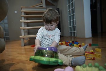 Image showing Adorable cute beautiful little baby girl playing with toys at home