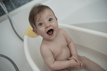 Image showing cute little baby girl taking a bath