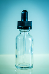 Image showing Glass dropper bottle on blue background