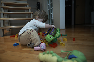 Image showing Adorable cute beautiful little baby girl playing with toys at home